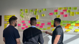 Group of people putting post it notes on a wall planner