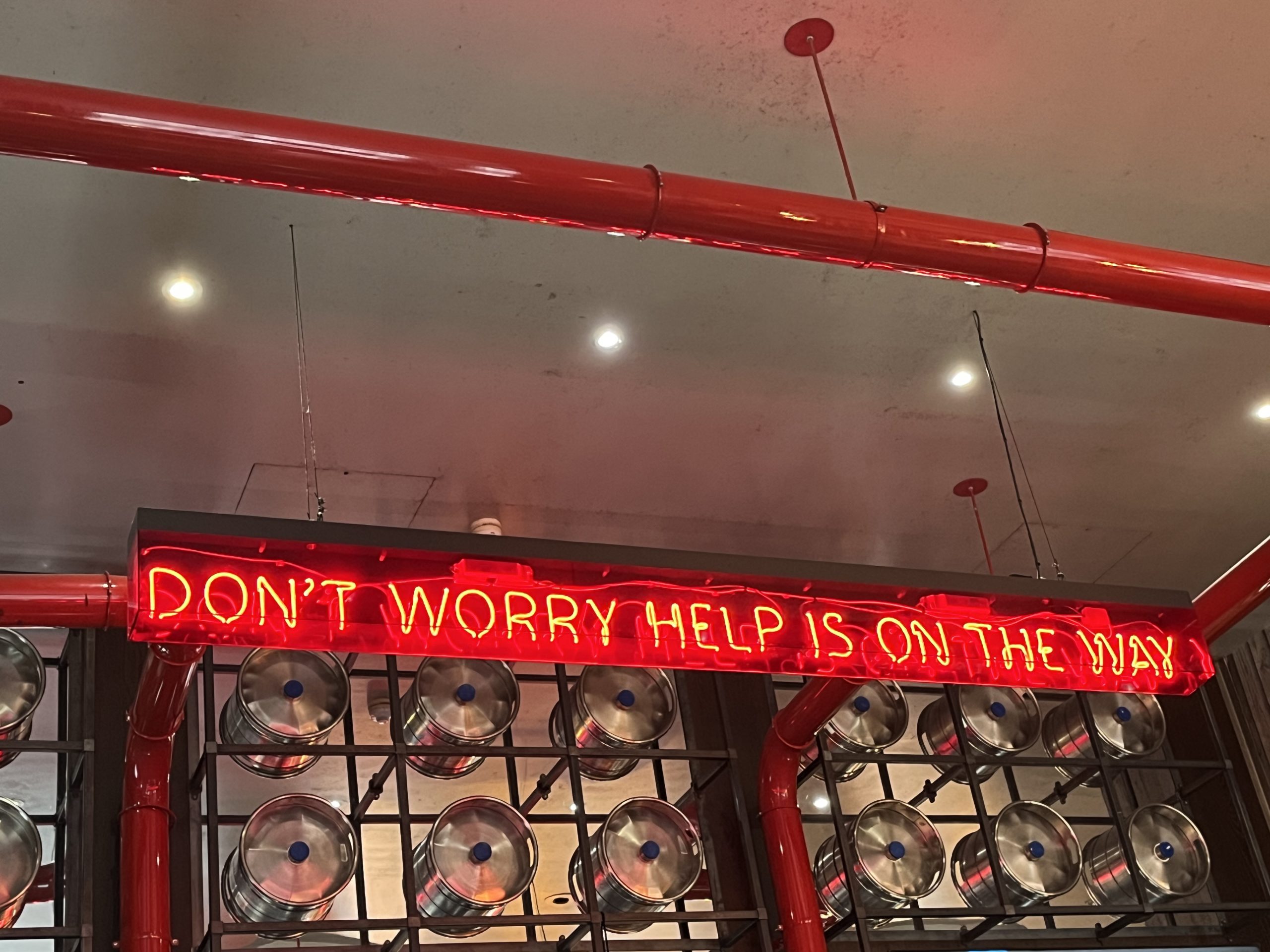 Neon sign saying Don't Worry Help Is On It's Way