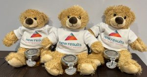 Soft toy bears wearing a New Results T Shirt and holding a small pot of honey